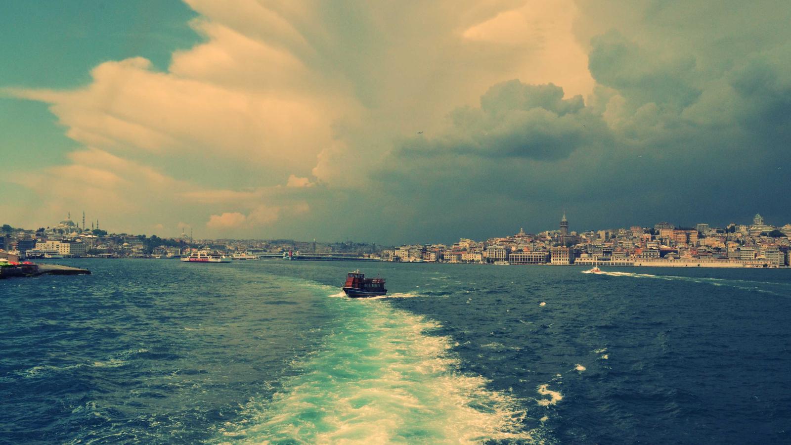 A printed paycheck stub on a desk next to a laptop